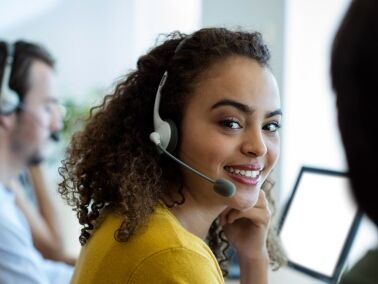 Servicemitarbeiterin mit Headset Servicemitarbeiter sitzend vor einem Computer mit einem Headset