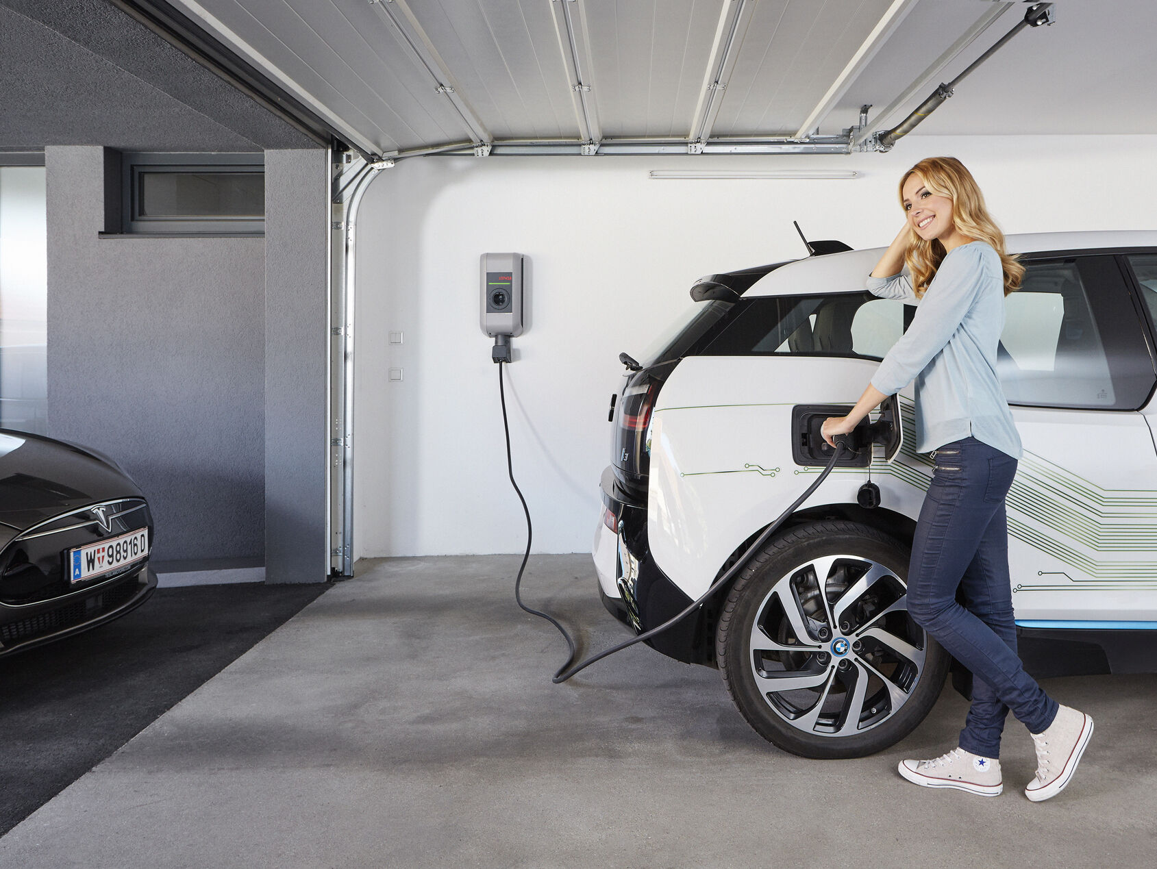 Frau lädt E-Auto mit Wallbox