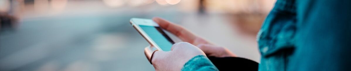 Person guckt auf ihrem Handy auf der Straße 
