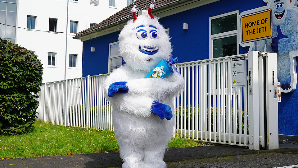 unser Jeti Maskottchen trägt eine blaue Schultüte und freut sich auf seine Einschulung 