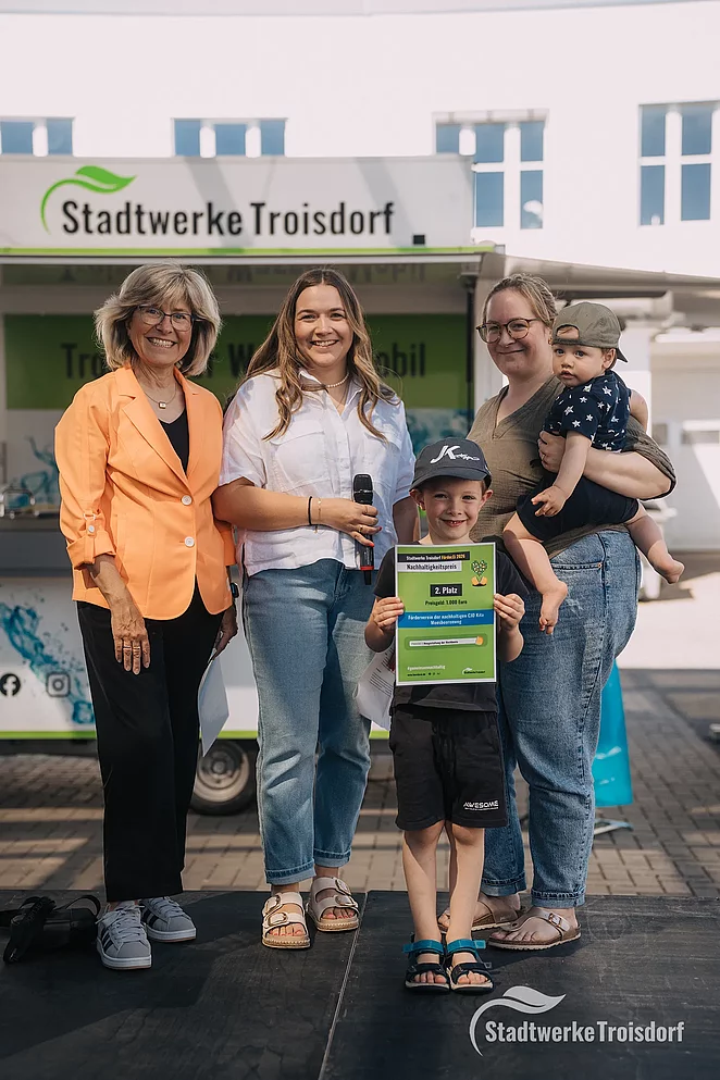 Stadtwerke Mitarbeiterinnen und Frau mit Kind bei Siegerehrung