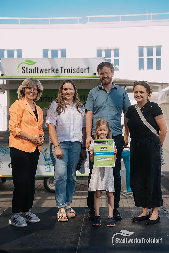 Stadtwerke Mitarbeiterinnen und Frau mit Mann und Kind bei Siegerehrung