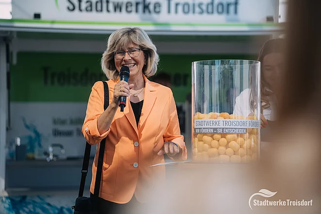 Geschäftsführerin steht mit Mikrofon auf dem Förder.Ei-Podium