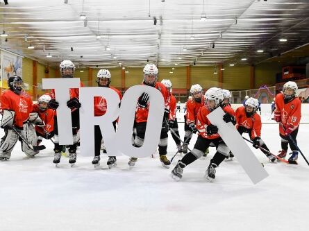 Gruppe spielt Eishockey Eishockeyspieler mit Troi Schriftzug