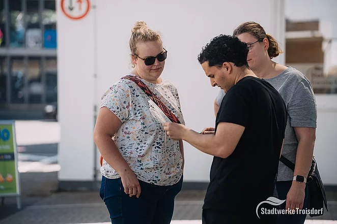 Zwei Frauen und Stadtwerke Mitarbeiter stehen zusammen bei der Anmeldung