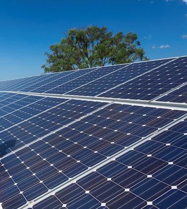 Solarpanelen werden auf Dach montiert Mann sitzt auf einem Dach mit Solaranlagen