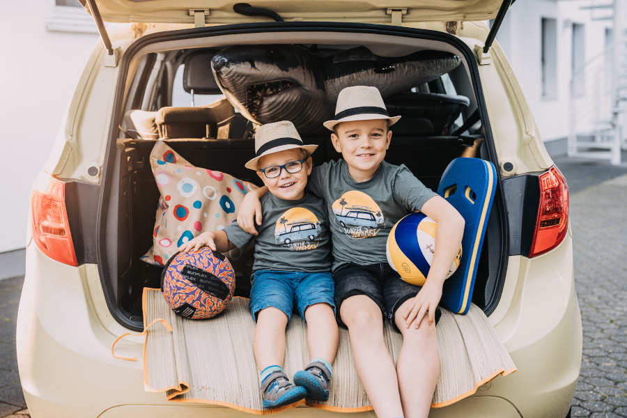 Zwei Kinder sitzen im Auto Zwei Kinder sitzen im Autokoffer